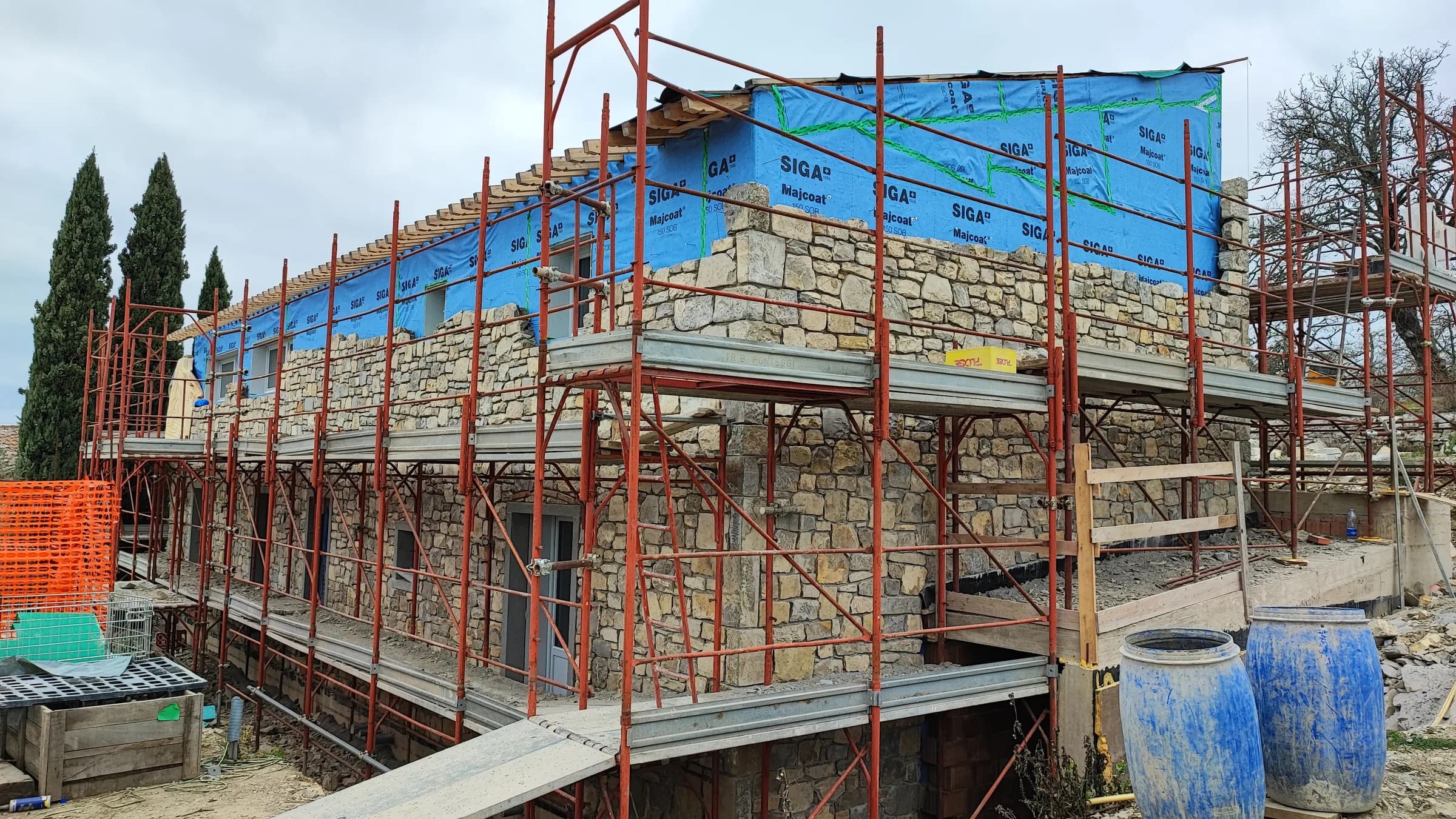 Il fabbricato tra i ponteggi durante la posa del rivestimento in pietra