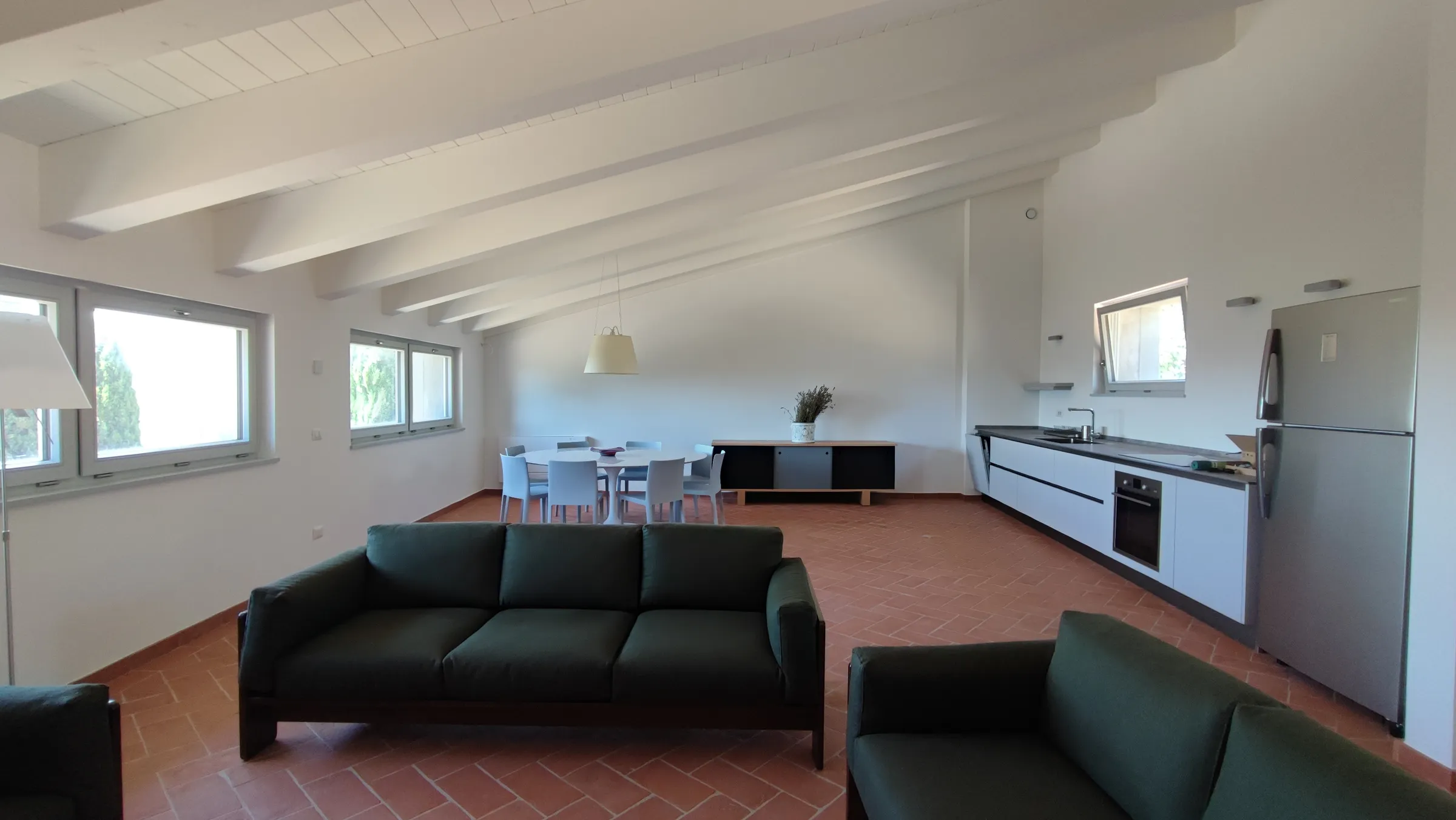 Soggiorno con cucina a vista e solaio in legno chiaro