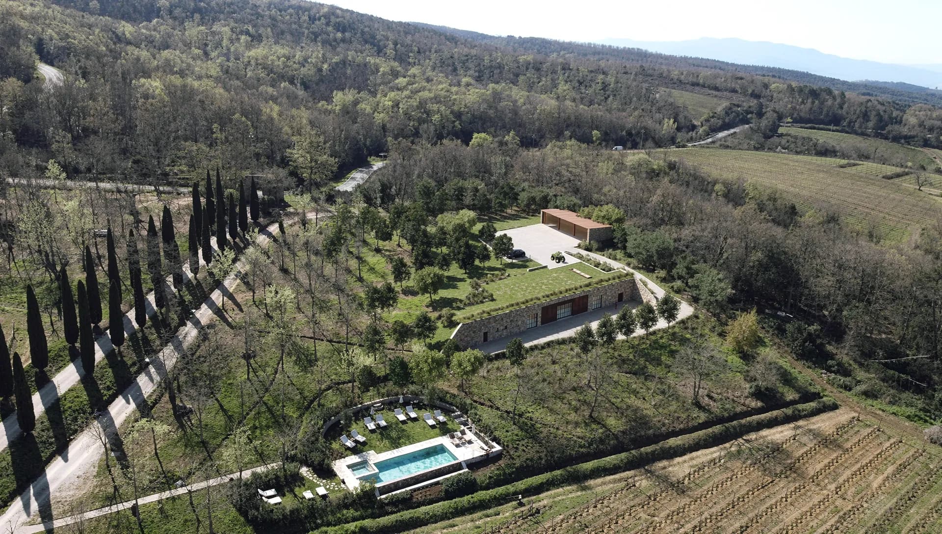 Rendering of the winery seen from above, with the garden roof among vineyards and cypresses